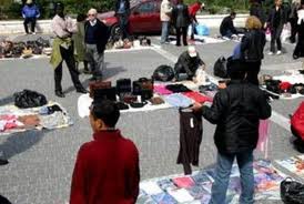 Δίνουν πρόστιμα σε καταστηματάρχες μπροστά στα μάτια των παράνομων αλλοδαπών με τα σεντόνια απλωμένα. Αίσχος!